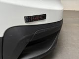 rear bumper of a white car with a sticker that says caution