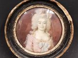 une vieille photo d'une femme en robe rose, dans un cadre rond