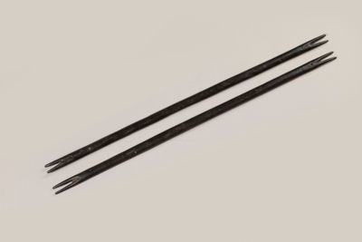 une paire de baguettes noires posées sur une surface blanche