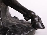 a statue of a man holding a dog ' s paw on a rock