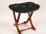 Ce petit tabouret est en bois et son assise est en velours noir.