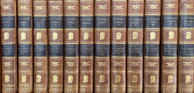 several old books are lined up on a shelf in a library