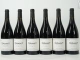 six bouteilles de vin sont alignées sur une table