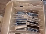 a box full of silverware sitting on the floor