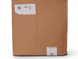 an open cardboard box on a white surface with a sticker on it