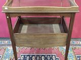 a small wooden table with a glass top on a rug