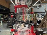 un mixeur rouge posé sur une étagère dans un magasin