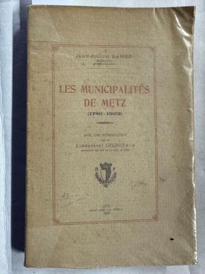 un vieux livre posé sur une table recouverte d'un tissu blanc