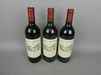 trois bouteilles de vin rouge posées côte à côte sur une table