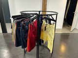 a rack of clothes that is on display in a room