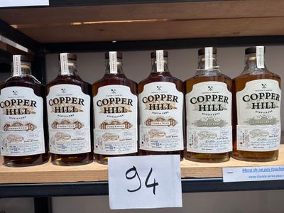 plusieurs bouteilles de whisky Copper Hill sur une étagère dans un magasin