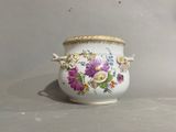 a vase with flowers painted on it sitting on a table