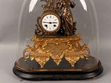 a clock under a glass dome on a table
