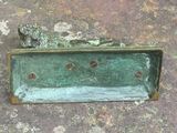 une statue en bronze représentant un chien assis sur une étagère