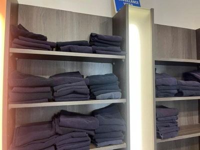 a lot of folded towels on the shelves in the store