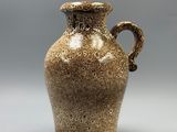 a brown vase that is sitting on a table