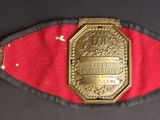 une vieille ceinture avec une boucle dorée sur une surface noire