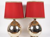 pair of silver and red lamps with red shades on a white background