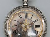 une montre de poche en argent avec des chiffres romains