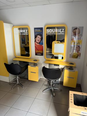deux chaises et une table dans une pièce dont les murs sont ornés d'affiches