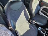 the interior of a small car with two seats and a steering wheel