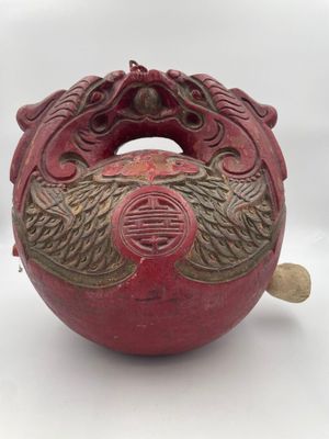 a red vase with a dragon on it on a white surface