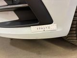 the front end of a white car with a sticker on it ' s bumper