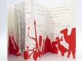 a folded book with a red design on it