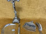 une assiette en argent ornée d'une croix, à côté d'un couteau et d'une cuillère