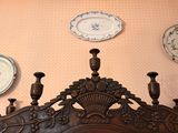 many decorative plates on the wall above the headboard