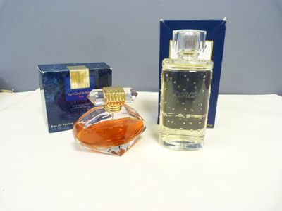 une image représentant un flacon de parfum posé à côté d'une boîte sur une table