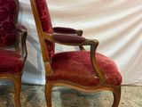 pair of red upholstered chairs sitting on a marble floor
