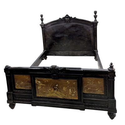 a black bed with gold decorations on the headboard