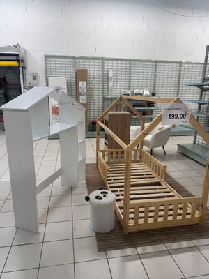 un lit en bois dans une chambre au sol carrelé de blanc