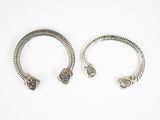 deux bracelets en argent posés sur une surface blanche, sur fond blanc