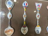 many spoons that are on display in a glass case
