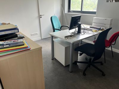 un bureau avec un ordinateur et une chaise dans une pièce