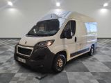 la camionnette blanche est garée dans une grande pièce au sol en damier