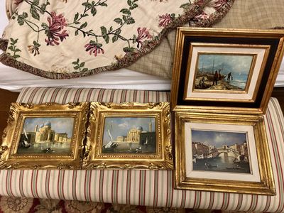 three paintings on a bench next to a bed
