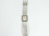 a close up of a watch on a white surface