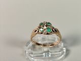 an image of a gold ring with green stones