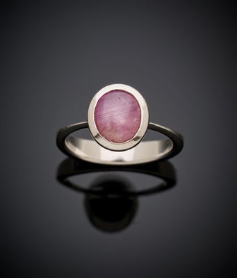 Gros plan sur une bague ornée d'une pierre rose