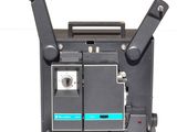 un vieux projecteur de cinéma posé sur une surface blanche