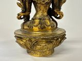 a gold statue of a woman with a bird on her head