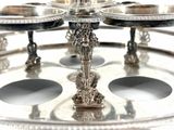 a silver plate with a silver candle holder on top of it