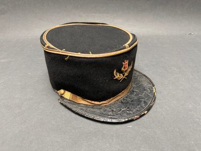 un chapeau noir orné d'une bordure dorée sur fond gris