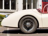 a white vintage car parked in front of a building