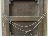 a small wooden box with a rope on it