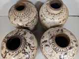 three white vases with designs on them sitting on a white surface
