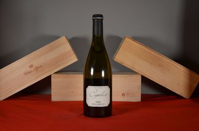 a bottle of wine sitting on a table next to two wooden boxes